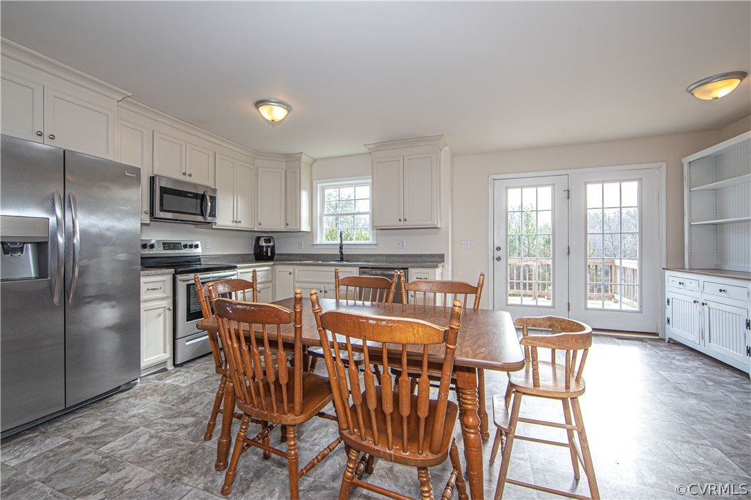 18951 Lundys Road Dinwiddie, VA 23841 - Photo 3 of 27 a kitchen with stainless steel appliances granite countertop a stove a refrigerator a kitchen island with a dining table and chairs