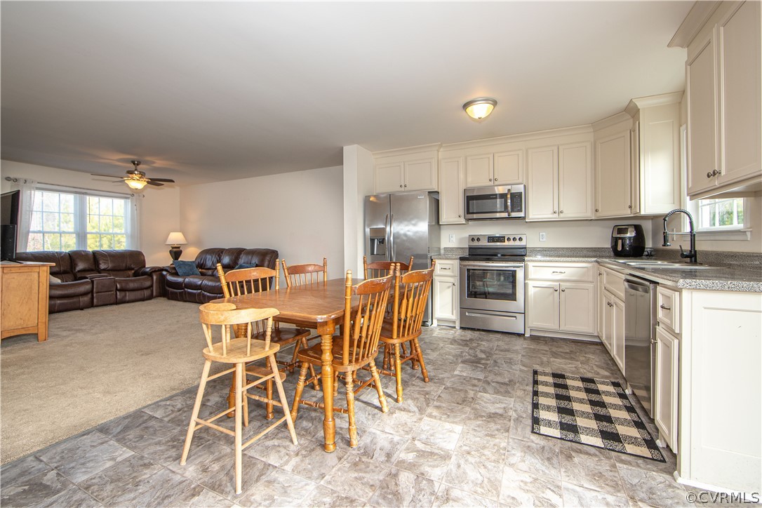 18951 Lundys Road Dinwiddie, VA 23841 - Photo 4 of 27 a kitchen with stainless steel appliances kitchen island granite countertop a stove a sink a dining table and chairs