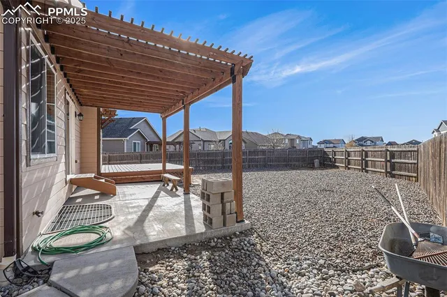 a view of a patio with table and chairs with wooden floor and fence