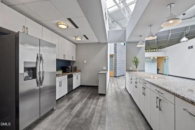 a view of livingroom with an empty room and wooden floor