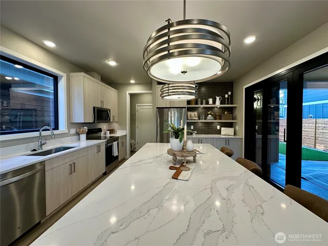 a kitchen with stainless steel appliances a sink a counter space cabinets and furniture