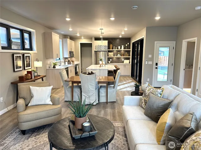 a living room with furniture kitchen and a large window