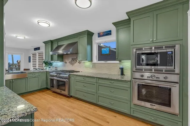 a kitchen with stainless steel appliances granite countertop a stove and cabinets