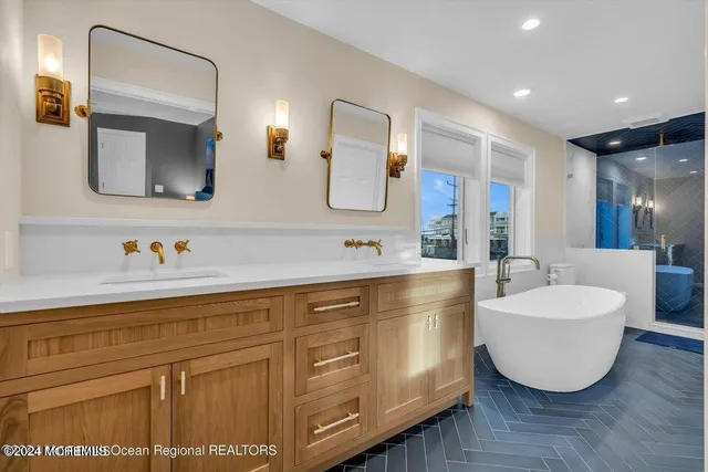 a spacious bathroom with a double vanity sink mirror and bathtub