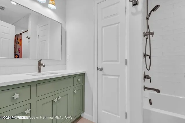 a spacious bathroom with a shower sink and mirror
