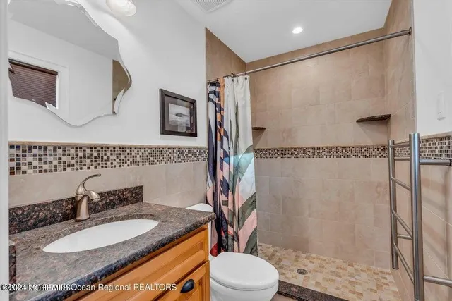a bathroom with a granite countertop sink toilet and shower