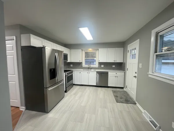 a kitchen with a refrigerator a sink and cabinets