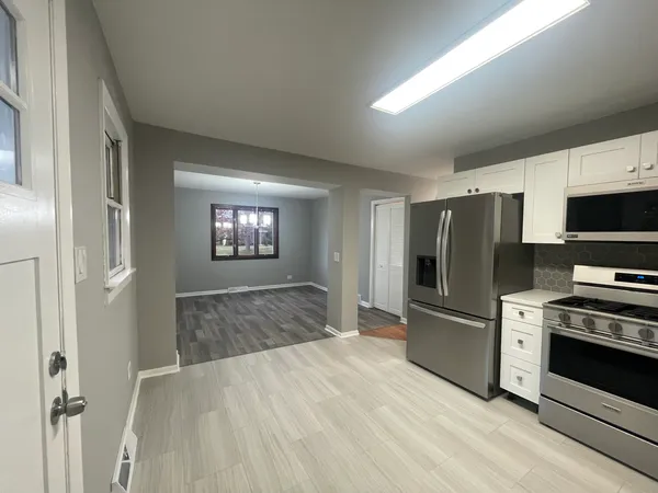 a open kitchen with refrigerator stove and microwave