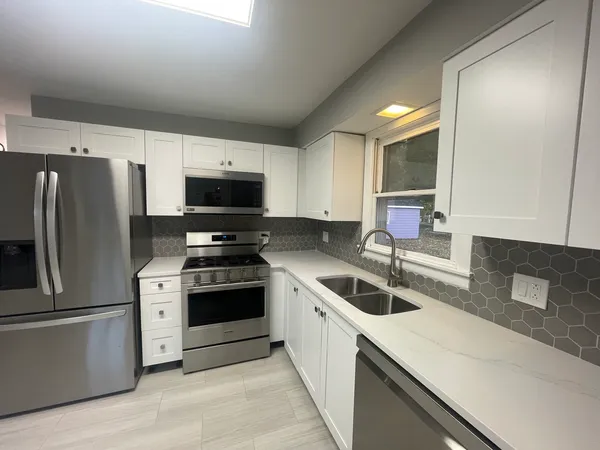 a kitchen with stainless steel appliances granite countertop a sink stove and refrigerator