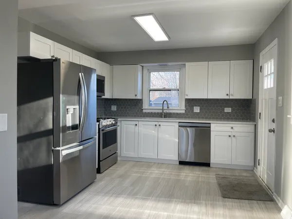 a kitchen with stainless steel appliances granite countertop a refrigerator sink and stove
