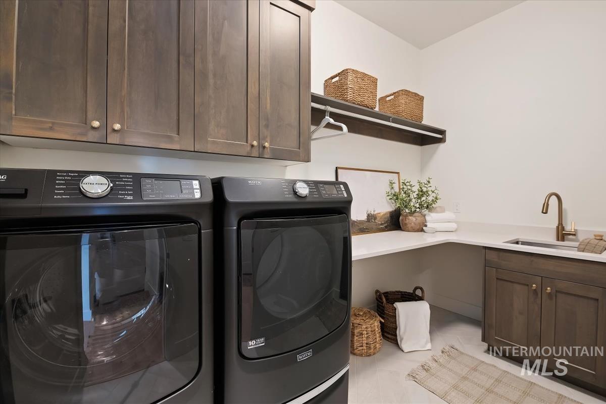 7615 Brown Way Eagle, ID 83714 - Photo 38 of 43 Laundry room featuring dark wood cabinetry, a built-in sink with a bronze-finish faucet, and a light-toned countertop