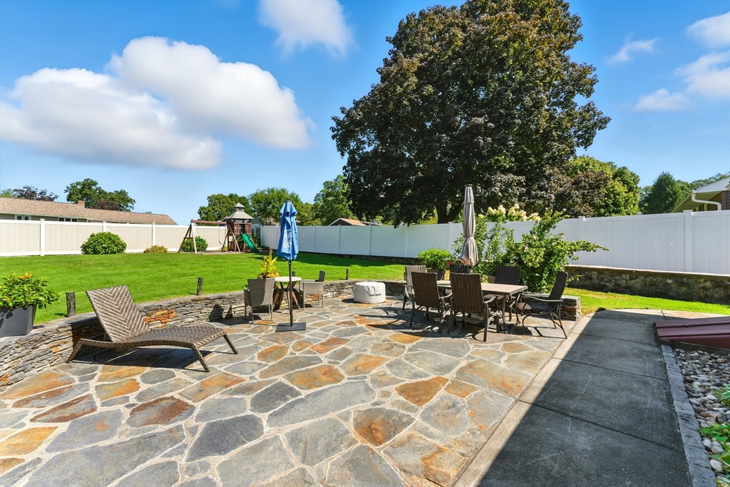 51 Newcrest Street Ludlow, MA 01056 - Photo 11 of 38 a view of a patio with table and chairs under an umbrella