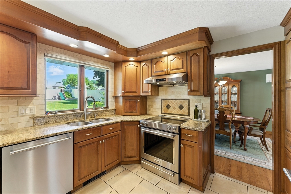 51 Newcrest Street Ludlow, MA 01056 - Photo 14 of 38 a kitchen with stainless steel appliances granite countertop a stove a sink and a refrigerator