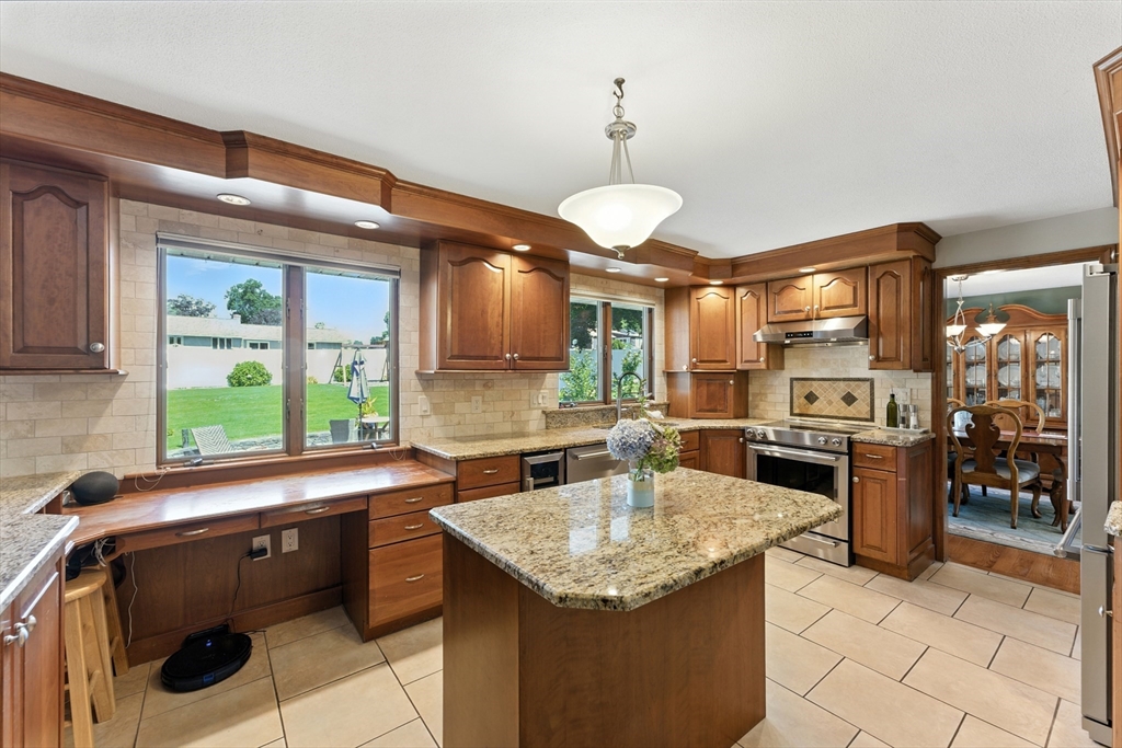 51 Newcrest Street Ludlow, MA 01056 - Photo 16 of 38 a kitchen with stainless steel appliances kitchen island granite countertop a sink and a refrigerator