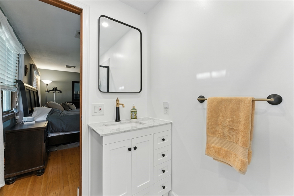 51 Newcrest Street Ludlow, MA 01056 - Photo 28 of 38 a bathroom with a granite countertop sink a mirror and shower
