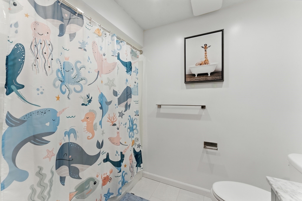 51 Newcrest Street Ludlow, MA 01056 - Photo 32 of 38 a bathroom with a toilet and a shower curtain