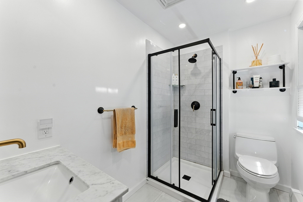 51 Newcrest Street Ludlow, MA 01056 - Photo 34 of 38 a bathroom with a shower bathtub mirror and toilet