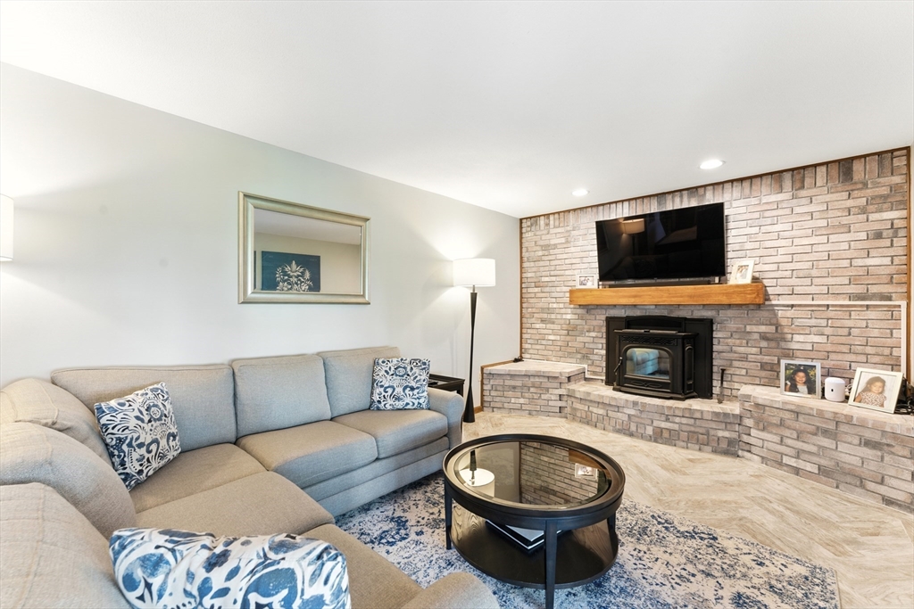 51 Newcrest Street Ludlow, MA 01056 - Photo 37 of 38 a living room with furniture a fireplace and flat screen tv