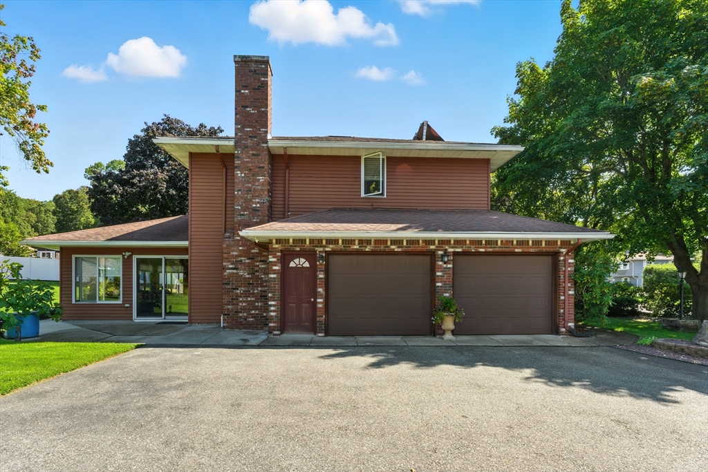 51 Newcrest Street Ludlow, MA 01056 - Photo 4 of 38 a front view of a house with a yard and garage
