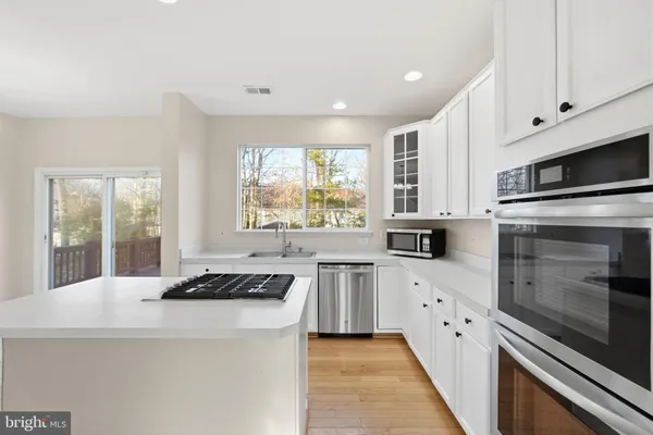 a kitchen with stainless steel appliances a stove sink microwave and cabinets