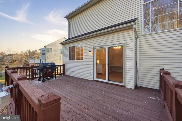 a view of a roof deck with table and chairs a barbeque with wooden floor and fence