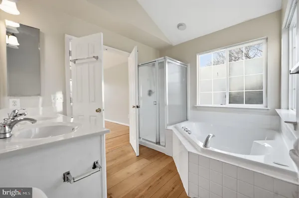 a bathroom with a tub sink and mirror