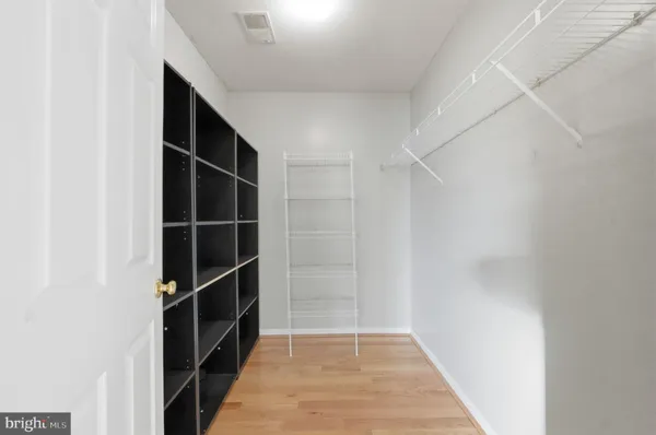 a view of walk in closet with empty racks