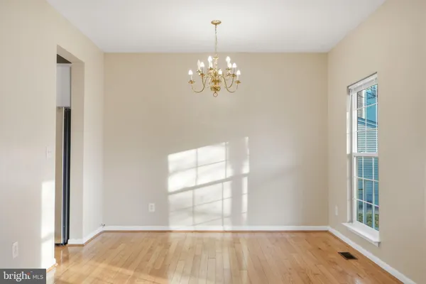 a view of a room with wooden floor and chandelier