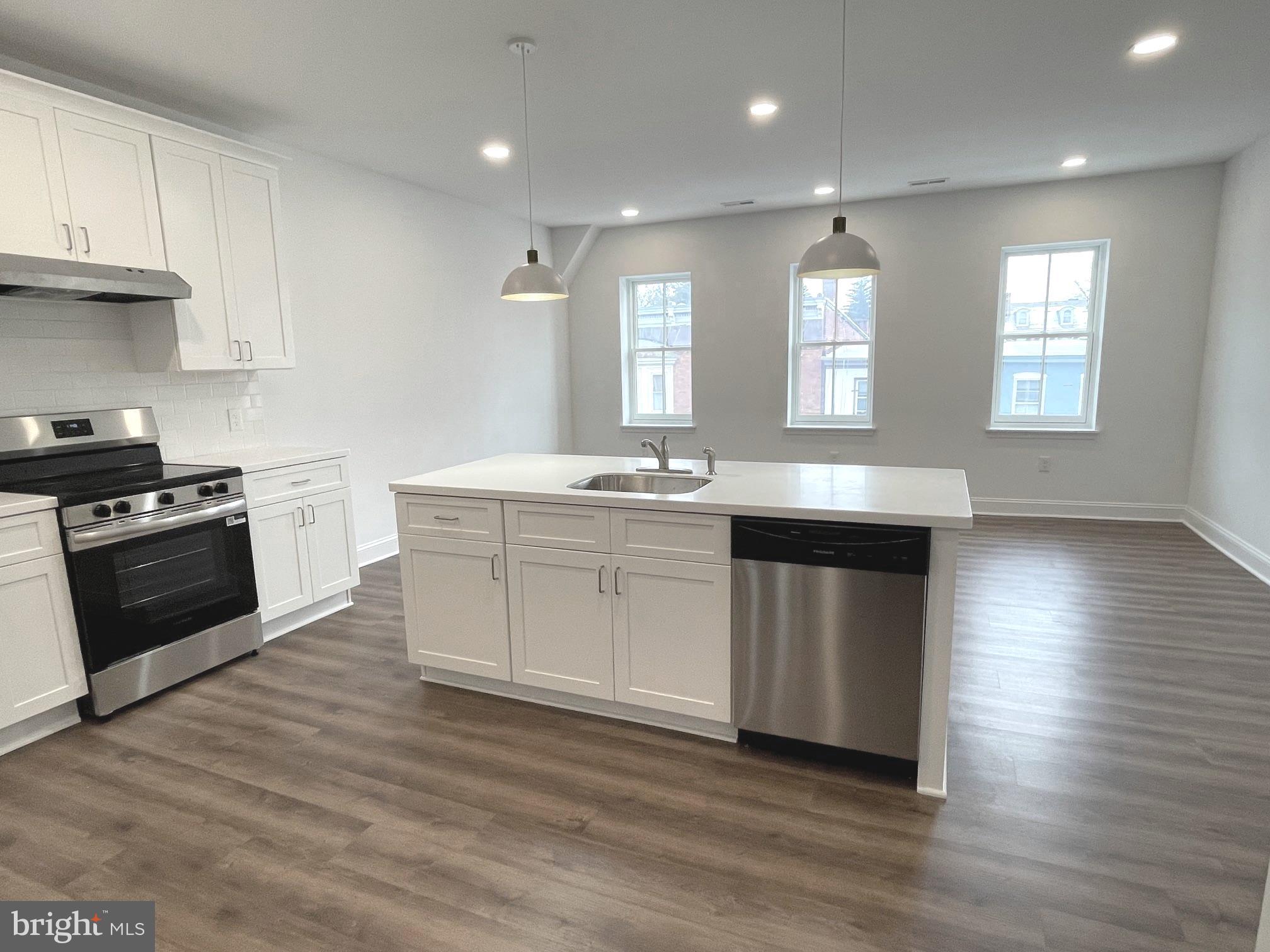 26 South State Street Newtown, PA 18940 - Photo 15 of 20 a kitchen with stainless steel appliances kitchen island granite countertop a stove a sink and white cabinets