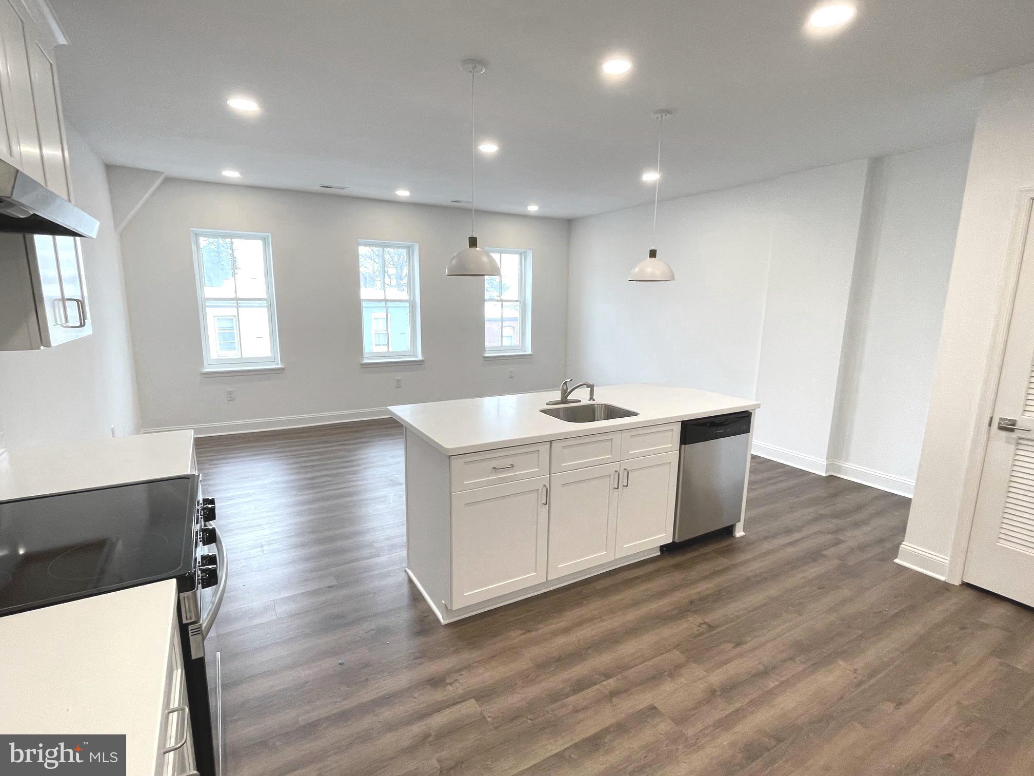 26 South State Street Newtown, PA 18940 - Photo 16 of 20 a large white kitchen with wooden floors and white walls