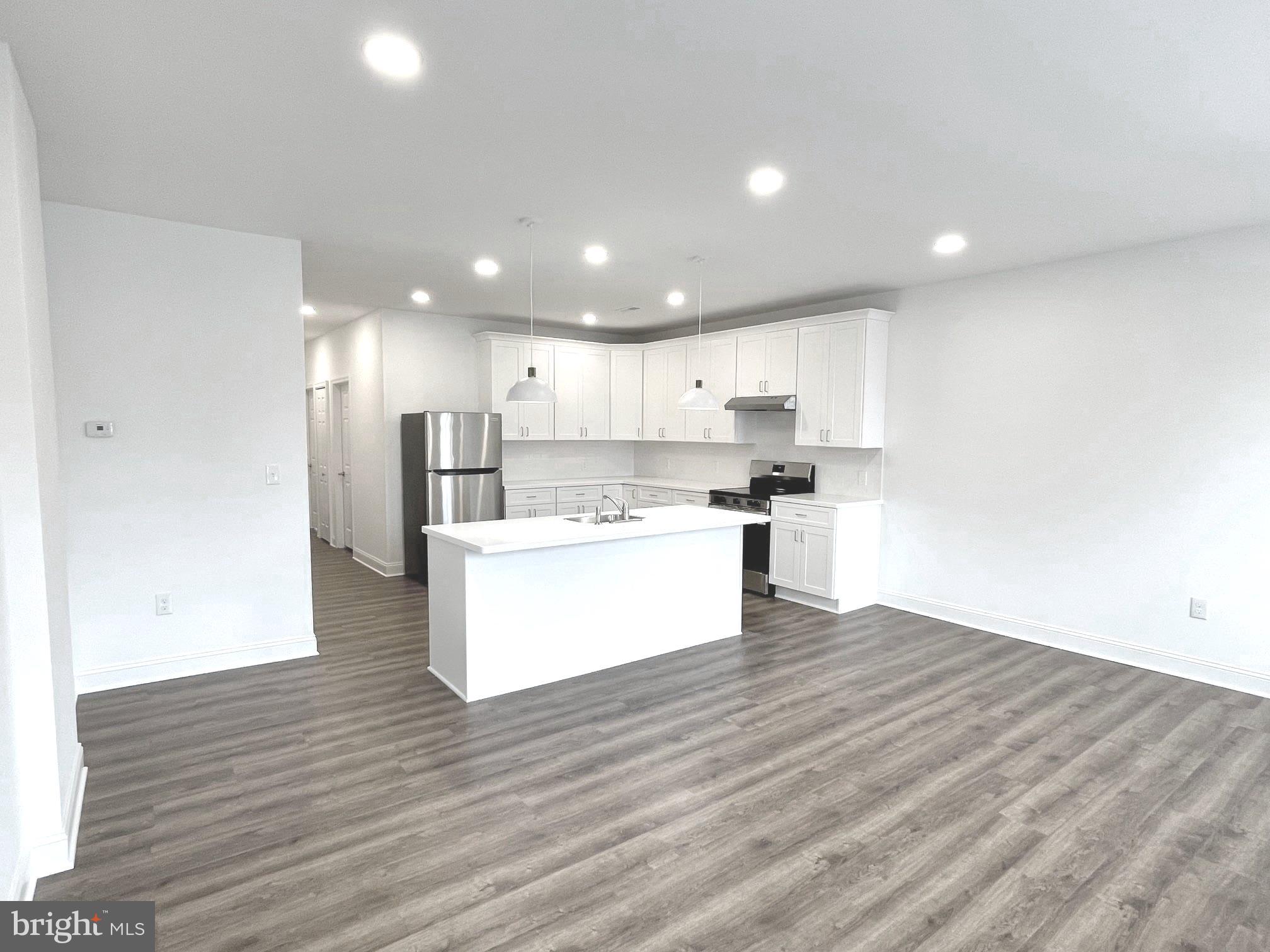 26 South State Street Newtown, PA 18940 - Photo 17 of 20 a view of kitchen with kitchen island wooden floor stainless steel appliances and cabinets