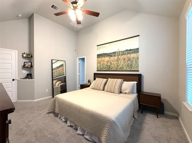 a bedroom with a large bed and a chandelier