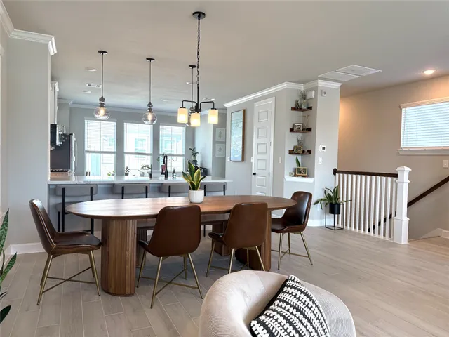 a dining room with furniture a chandelier and wooden floor