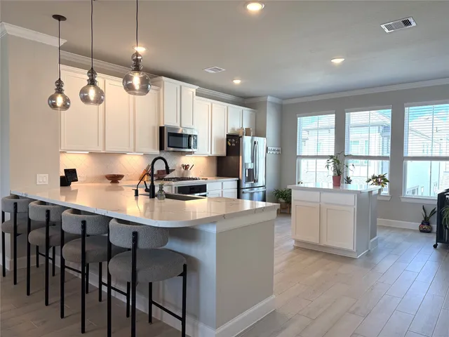 a kitchen with kitchen island white cabinets and refrigerator