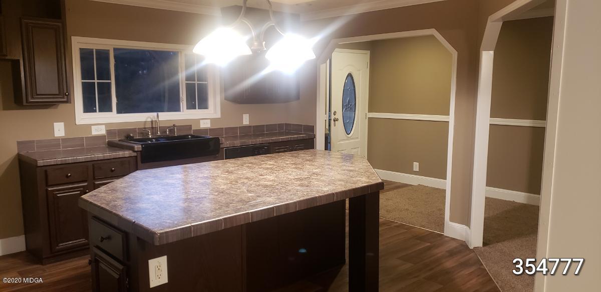 5700 Taylor Road Lizella, GA 31052 - Photo 3 of 23 a kitchen with a sink a counter space and cabinets