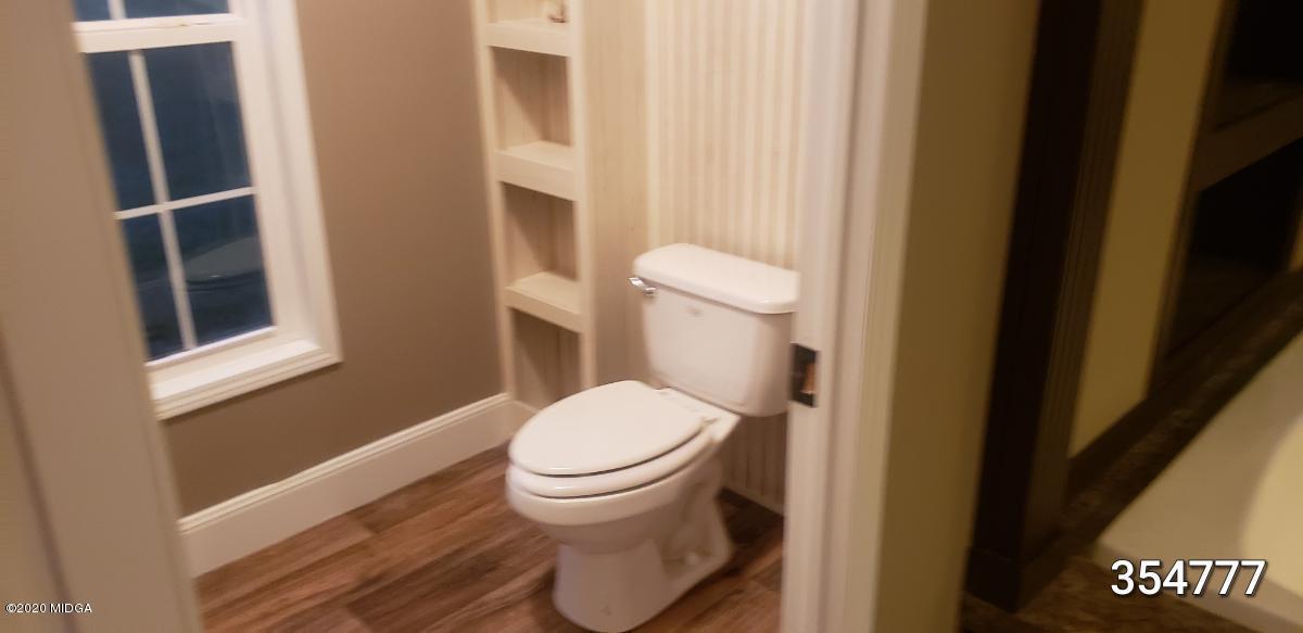 5700 Taylor Road Lizella, GA 31052 - Photo 10 of 23 a white toilet sitting next to a shower curtain