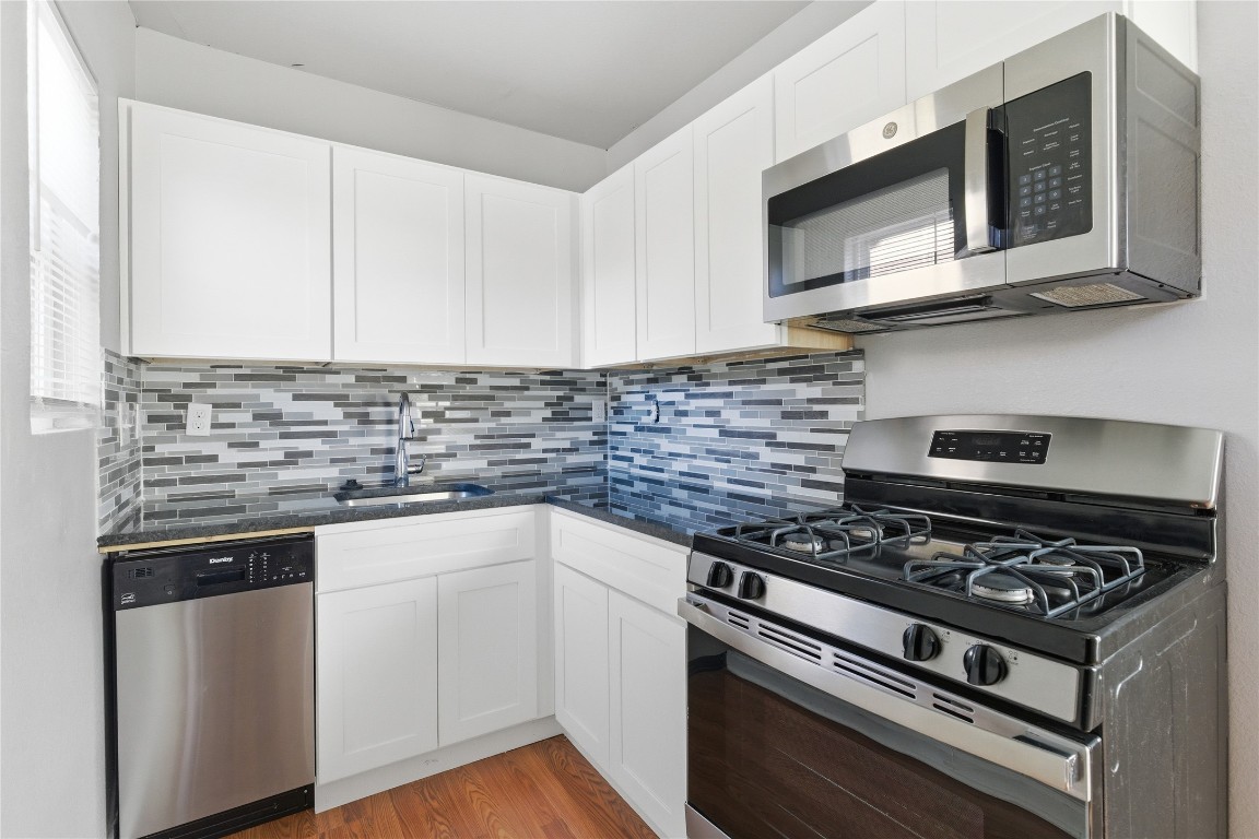 a kitchen with stainless steel appliances granite countertop a stove and a microwave
