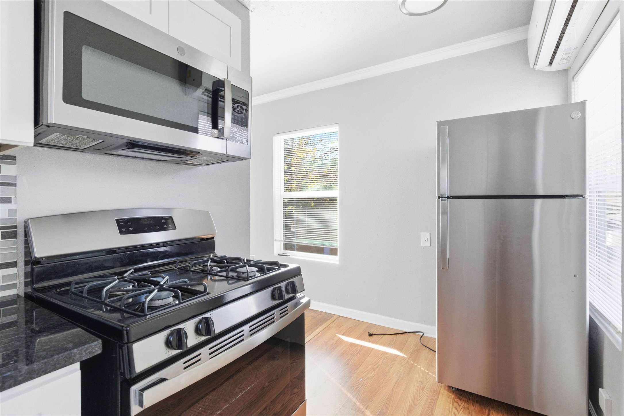 204 East 30th Street, Unit 201 Austin, TX 78705 - Photo 3 of 18 a kitchen with stainless steel appliances granite countertop a stove and a microwave