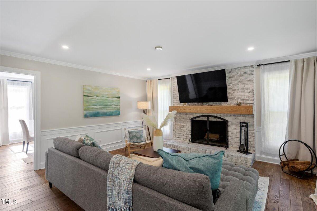 7209 Halstead Lane Raleigh, NC 27613 - Photo 18 of 64 a living room with furniture a flat screen tv and a fireplace