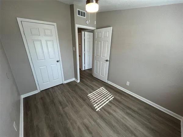 a view of a room with wooden floor and white walls