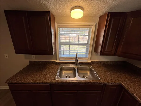 a view of a sink a mirror and cabinets