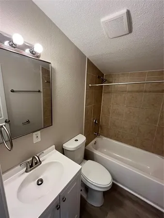 a bathroom with a toilet a sink a mirror and shower