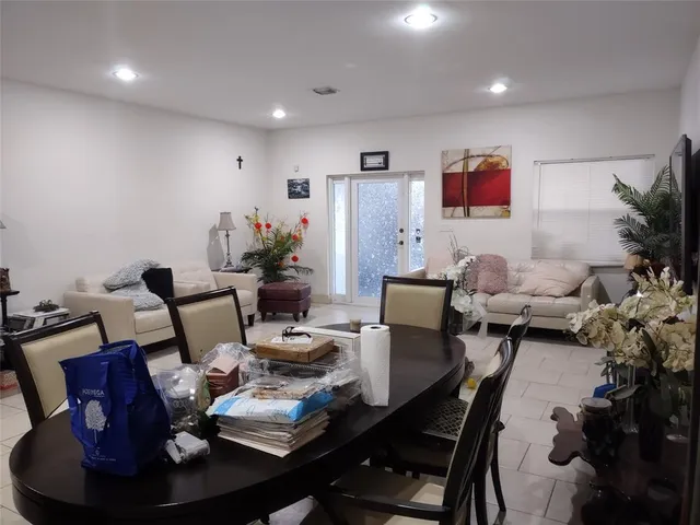 a living room with furniture kitchen view and a potted plant