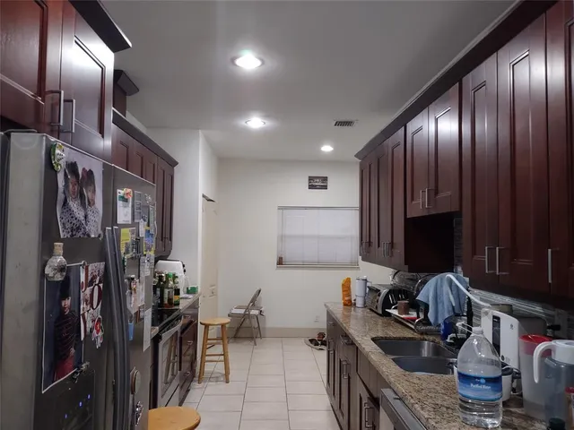 a kitchen with granite countertop wooden cabinets and sink