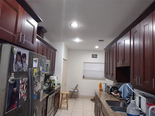 a kitchen with granite countertop wooden cabinets and stainless steel appliances