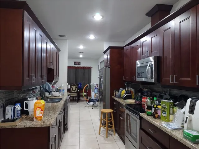 a kitchen with stainless steel appliances granite countertop a stove refrigerator and cabinets