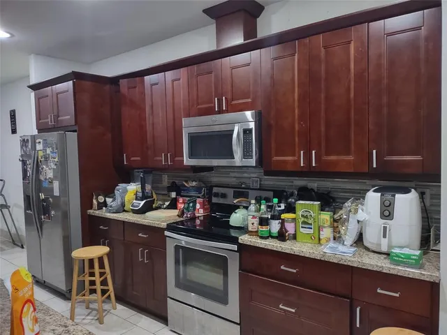 a kitchen with stainless steel appliances granite countertop a refrigerator and a sink