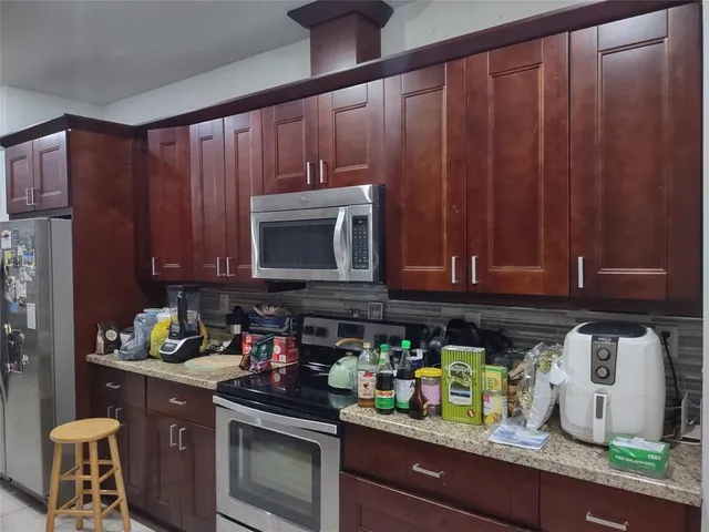 a kitchen with stainless steel appliances a stove a sink and a microwave