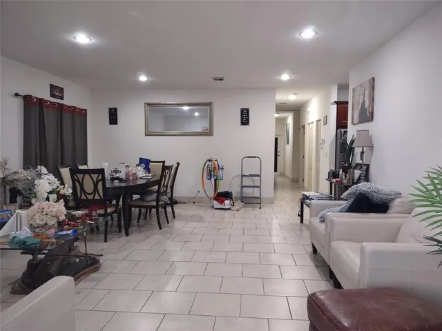 a living room with furniture a flat screen tv and kitchen view