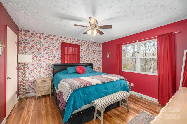 a bedroom with a bed and a dresser next to a window